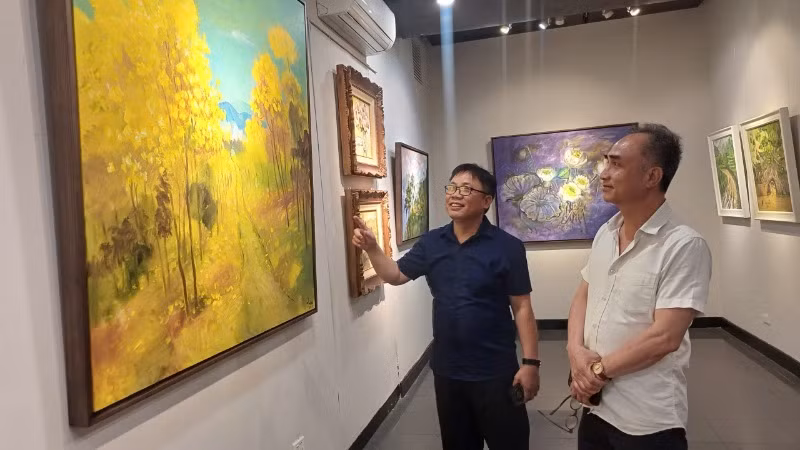 Họa sĩ Quỳnh Thơm (bên trái) giới thiệu về tác phẩm của mình.