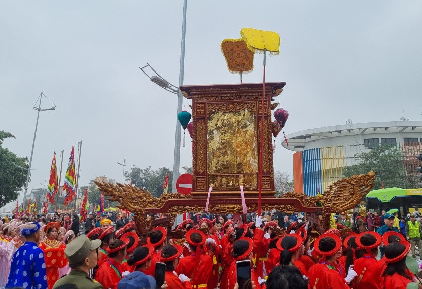 Người dân rước kiệu thánh ra sông Hồng làm lễ rước nước tại Lễ hội Đình Nhật Tân. (Ảnh: DIỆP VÂN)