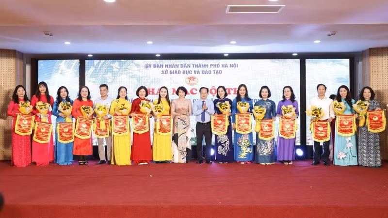 Phó Vụ trưởng Giáo dục Mầm non (Bộ Giáo dục và Đào tạo) Hoàng Thị Dinh và Giám đốc Sở Giáo dục và Đào tạo Hà Nội Trần Thế Cương tặng cờ lưu niệm cho các đơn vị tham dự hội thi.