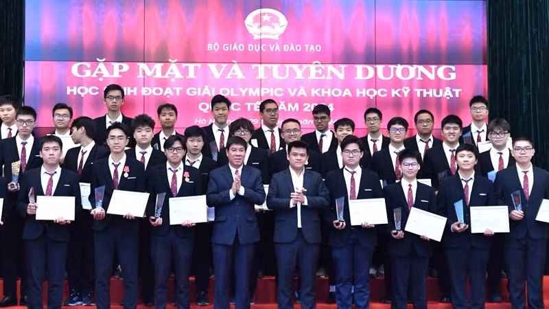 Cục trưởng Quản lý chất lượng (Bộ Giáo dục và Đào tạo) Huỳnh Văn Chương và ông Lê Đình Lực (Trung tâm Tiếng Anh DOL IELTS Đình Lực) trao Kỷ niệm chương và học bổng cho các em học sinh. (Ảnh: PHAN LINH)