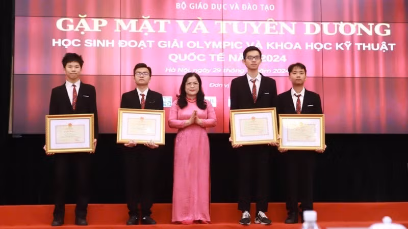 Thứ trưởng Nguyễn Thị Kim Chi trao Bằng khen của Bộ Giáo dục và Đào tạo cho các em học sinh đoạt giải. (Ảnh: PHAN LINH)