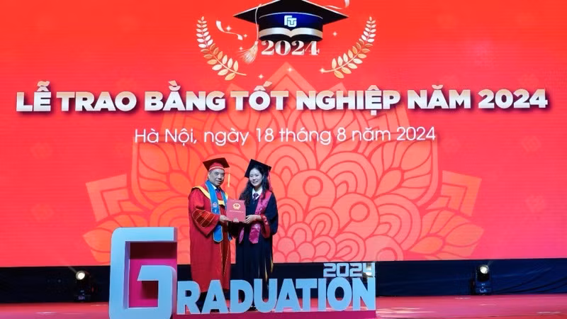 Hiệu trưởng Trường đại học Ngoại thương Phó Giáo sư, Tiến sĩ Bùi Anh Tuấn trao bằng tốt nghiệp cho thủ khoa tốt nghiệp Nguyễn Khánh Linh và các tân cử nhân. 