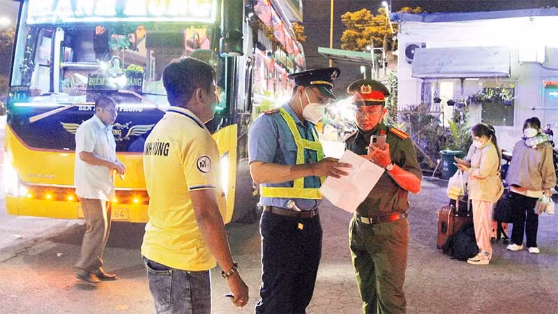 Thanh tra giao thông, Sở Giao thông vận tải phối hợp Công an phường Tam Bình, thành phố Thủ Đức kiểm tra một điểm “xe dù”có xe khách hoạt động trên Quốc lộ 1A. (Ảnh THẾ ANH)