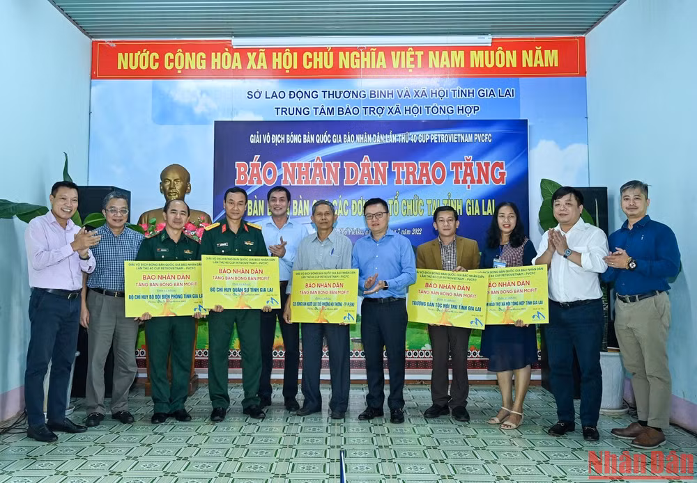 Tổng Biên tập Báo Nhân Dân Lê Quốc Minh cùng các đại biểu và nhà tài trợ trao tặng bàn bóng bàn cho các đơn vị. 