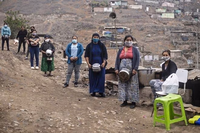 Người dân gặp khó khăn do ảnh hưởng của dịch Covid-19 xếp hàng chờ nhận lương thực cứu trợ ở ngoại ô thủ đô Lima, Peru ngày 28/5/2020. (Ảnh: AFP/TTXVN)