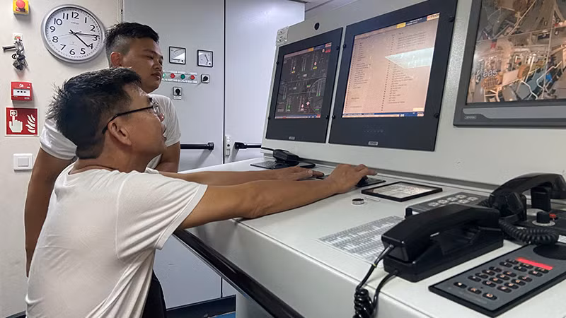 Kíp trực KN390 trong hầm máy đang theo dõi các thiết bị điện tử tối tân trong quá trình vận hành tàu.