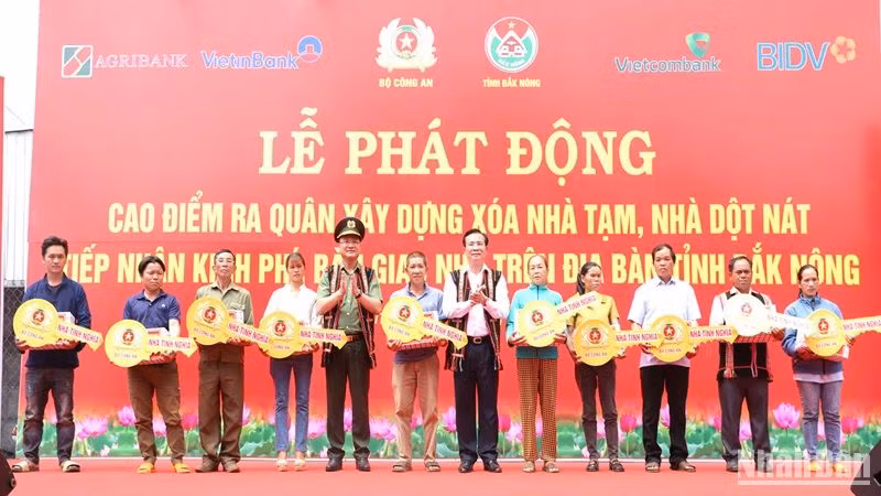 Thứ trưởng Công an Phạm Thế Tùng và Chủ tịch Ủy ban nhân dân tỉnh Đắk Nông Hồ Văn Mười trao chìa khóa tượng trưng cho các hộ dân được hưởng chính sách từ chương trình.