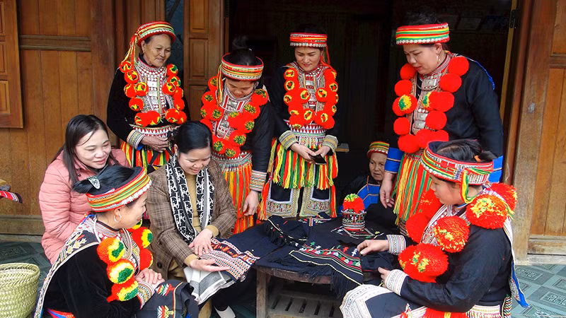 Phụ nữ dân tộc Dao thôn Bản Cuôn, xã Ngọc Phái, huyện Chợ Đồn giới thiệu các sản phẩm cho du khách. (Ảnh HƯƠNG LIỄU)