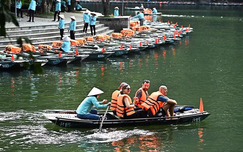 Khách du lịch quốc tế tham quan danh thắng Tràng An (Ninh Bình). (Ảnh ÐĂNG KHOA) 