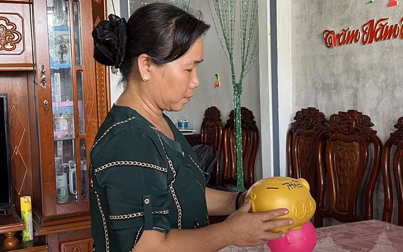 Hội viên Hội Phụ nữ huyện Trà Cú (Trà Vinh) nuôi heo đất tiết kiệm để tham gia bảo hiểm xã hội tự nguyện. (Ảnh KIM THANH) 