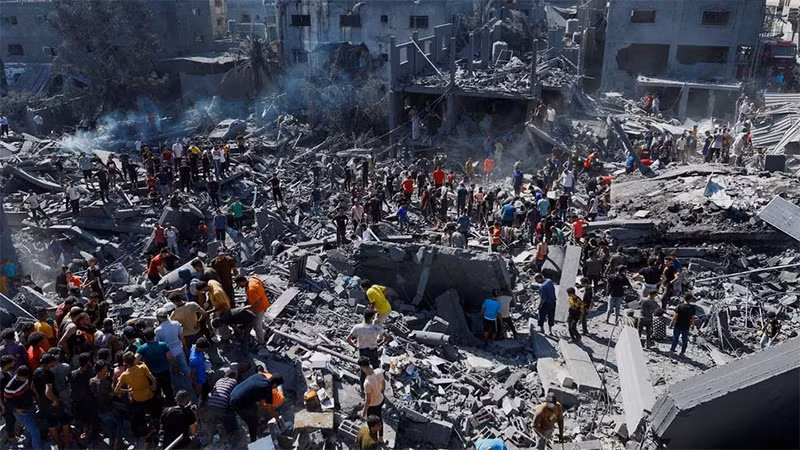 Những người Palestine đang tìm kiếm người thương vong tại khu vực bị Israel tấn công ở phía nam Dải Gaza, ngày 26/10/2023. Ảnh: Reuters