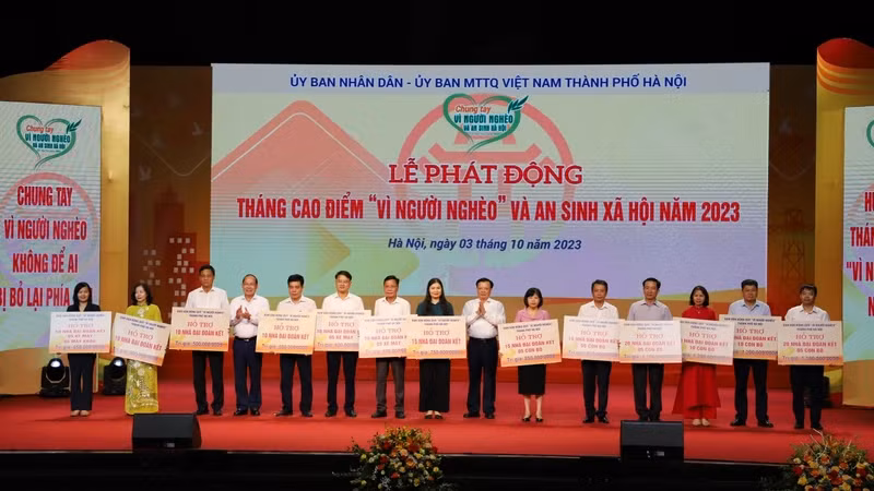 Bí thư Thành ủy Hà Nội Đinh Tiến Dũng và Phó Chủ tịch Ủy ban Mặt trận Tổ quốc Việt Nam Hoàng Công Thủy trao kinh phí hỗ trợ hộ nghèo cho các huyện, thị xã của Hà Nội.
