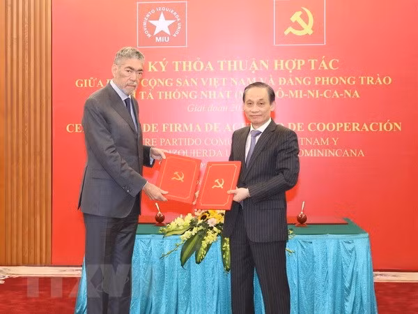 Ông Lê Hoài Trung, Ủy viên Trung ương Đảng, Trưởng Ban Đối ngoại Trung ương và ông Miguel Mejia, Tổng Bí thư Đảng Phong trào cánh tả thống nhất Dominica trao bản thỏa thuận hợp tác giữa hai Đảng. (Ảnh: TTXVN)