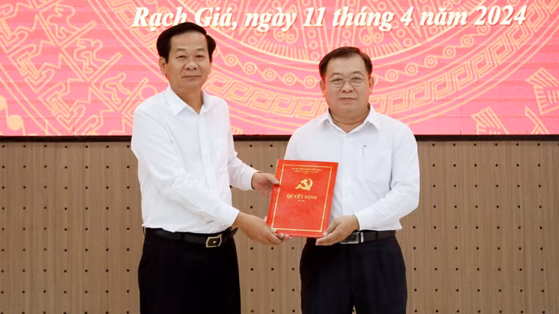 Bí thư Tỉnh ủy Kiên Giang Đỗ Thanh Bình (bên trái) trao quyết định, tặng hoa chúc mừng đồng chí Lê Thanh Việt.