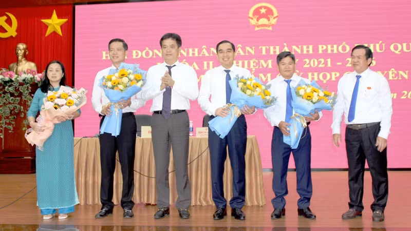 Bí thư Thành ủy Phú Quốc Lê Quốc Anh (thứ 3 từ trái qua) tặng hoa chúc mừng tân Chủ tịch Ủy ban nhân dân thành phố Phú Quốc Trần Minh Khoa (thứ 2 từ trái qua).