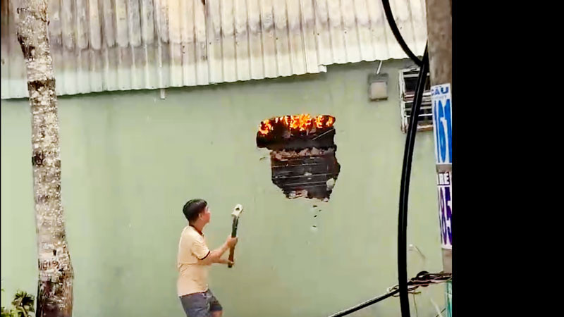 Lực lượng tham gia chữa cháy đập tường để tiến hành chữa cháy. 