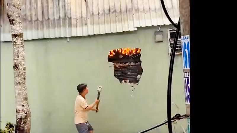 Lực lượng tham gia chữa cháy đập tường để tiến hành chữa cháy. 