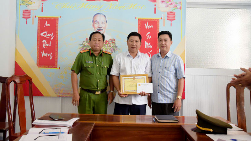 Đại diện Công an huyện Vĩnh Thuận và lãnh đạo xã Vĩnh Bình Bắc trao giấy khen cho anh Nguyễn Xuân Trọn. (Ảnh: Công an xã Vĩnh Bình Bắc cung cấp)