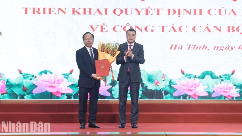 Đồng chí Lê Minh Hưng trao Quyết định của Bộ Chính trị và tặng hoa chúc mừng tân Bí thư Tỉnh ủy Hà Tĩnh Nguyễn Duy Lâm.