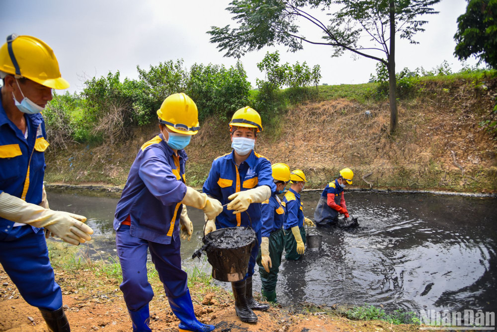 Những người công nhân chuyền tay nhau những xô chất thải để đem lên bờ xử lý. Những người công nhân chuyền tay nhau những xô chất thải để đem lên bờ xử lý.