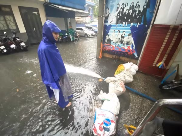 Người dân ở một tuyến hẻm trên đường Nguyễn Thị Minh Khai, quận 1 dùng bao chắn cát và máy bơm để "chống ngập".