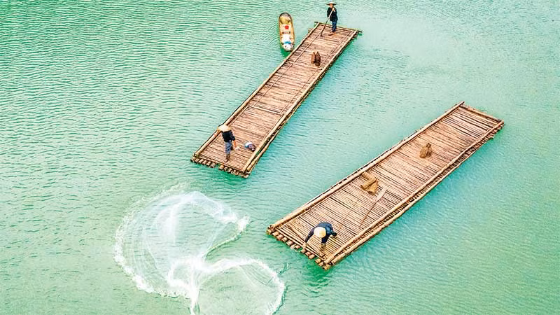 Ngư dân quăng chài trên hồ Thang Hen. (Ảnh ĐỖ TUẤN HÙNG)