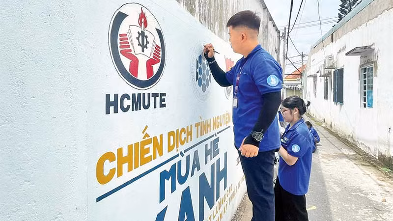 Các chiến sĩ Mùa hè xanh sơn sửa và vẽ tranh cổ động trên bức tường ở Khu phố 4, phường Tăng Nhơn Phú.