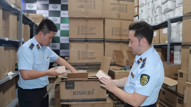 Lực lượng quản lý thị trường tỉnh Lạng Sơn hướng dẫn các hộ kinh doanh chấp hành quy định pháp luật trong kinh doanh, buôn bán. (Ảnh: LƯU QUYÊN)
