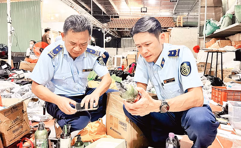 Lực lượng quản lý thị trường kiểm tra một kho hàng kinh doanh online các sản phẩm giả nhãn hiệu trên địa bàn TP Pleiku, tỉnh Gia Lai. (Ảnh QUYÊN LƯU)