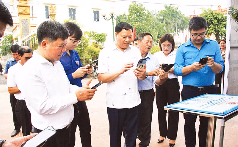 Các đại biểu thao tác quét mã QR tại đình Triều Hội.