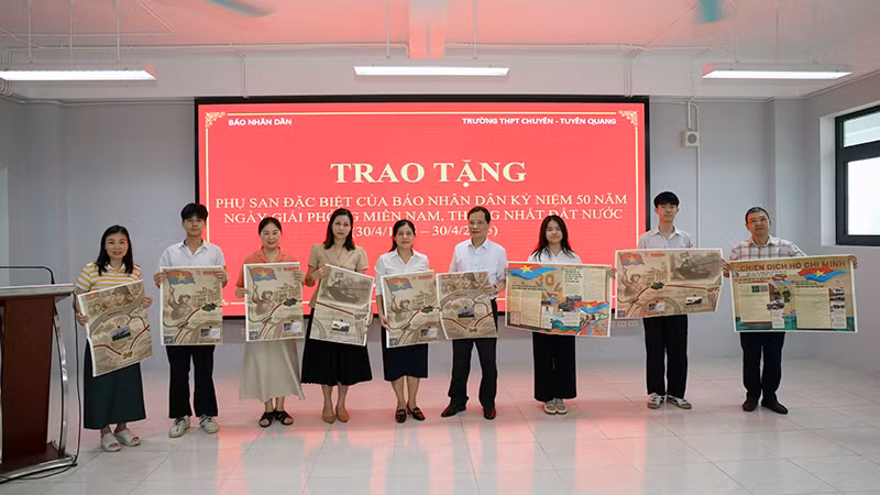 Trưởng Văn phòng đại diện Báo Nhân Dân tại Tuyên Quang trao tặng phụ san đặc biệt cho thầy, cô giáo và các em học sinh trường THPT Chuyên Tuyên Quang.