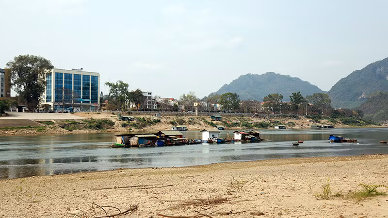 Người nuôi cá lồng trên sông Lô lựa dòng nước để di chuyển lồng nuôi cá đến nơi nước sâu hơn.