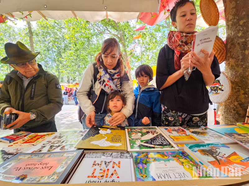 Chị Ariane Louvet cùng các con ghé qua một gian hàng để tìm mua sách truyện tiếng Việt. (Ảnh: KHẢI HOÀN)