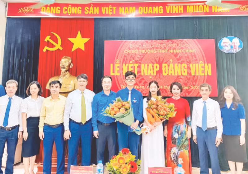 Bí thư Quận ủy Thanh Xuân, Bùi Huyền Mai và các đại biểu chúc mừng hai đảng viên trẻ tại Chi bộ trường THPT Nhân Chính. (Ảnh HỒNG THÁI)