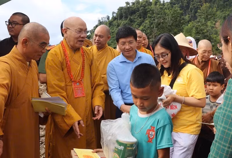 Hòa thượng Thích Quảng Tùng cùng đồng chí Mùa A Vảng, trao quà tặng người dân vùng lũ.