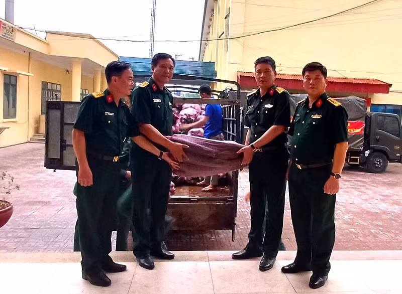 Đại diện cán bộ Ban Chỉ huy quân sự huyện Nậm Pồ trao bí xanh để các bộ phận chế biến phục vụ lực lượng diễu binh, diễu hành.