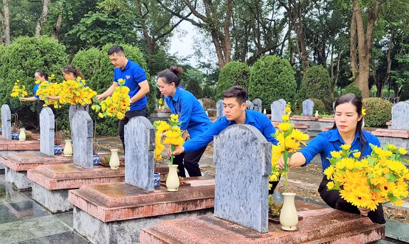 Đoàn viên thanh niên tỉnh Điện Biên thay mới các lọ hoa trên từng phần mộ liệt sĩ tại Nghĩa trang liệt sĩ Độc Lập.