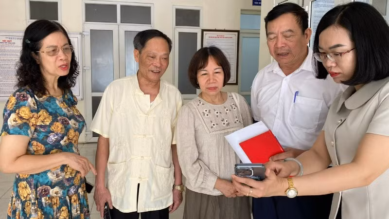 Đồng chí Hà Thị Phương Dung, Phó Chủ tịch Ủy ban nhân dân phường Bưởi trao đổi với người dân về ứng dụng công nghệ số.