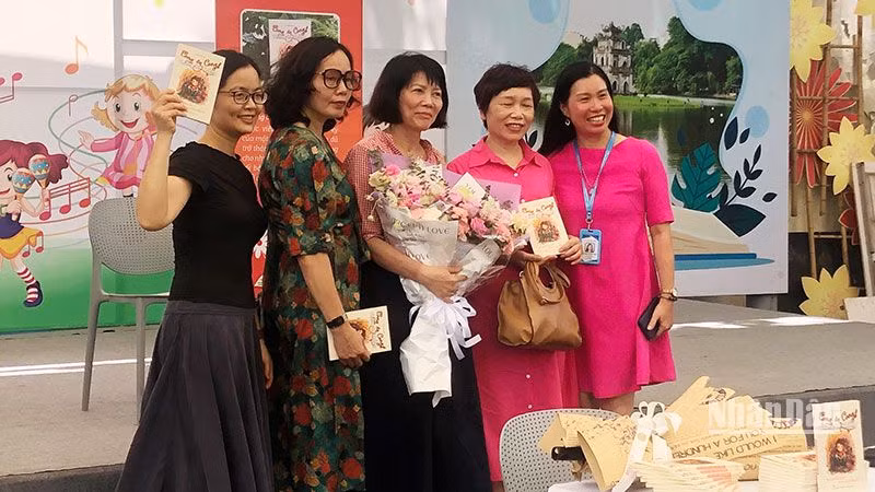 Tác giả Vũ Thị Minh Họa (ôm hoa, đứng giữa) tại buổi ra mắt sách.