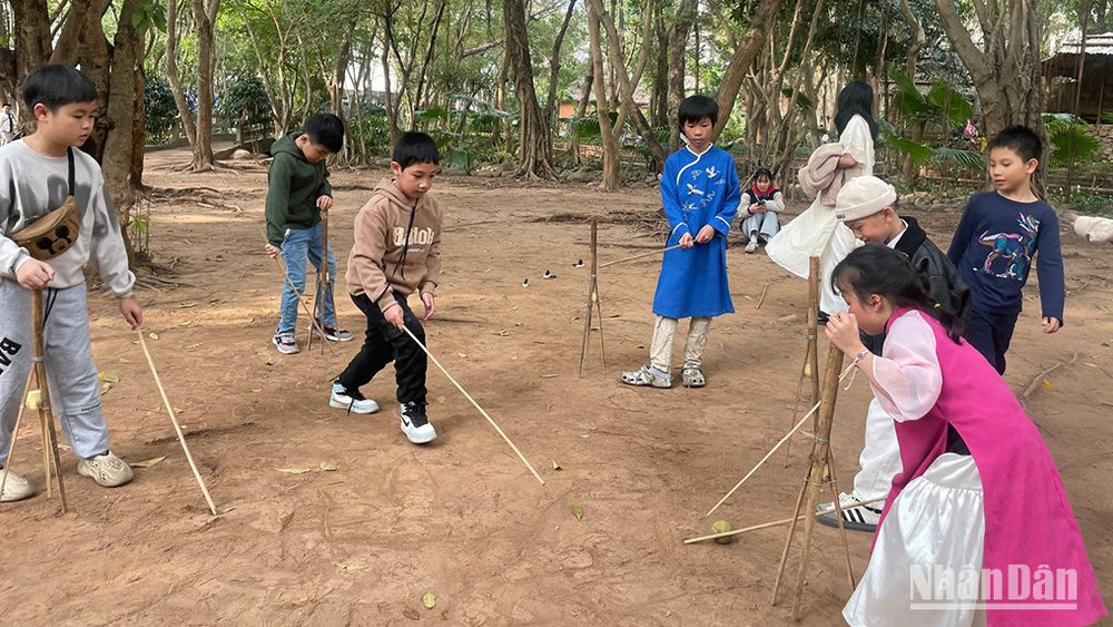 Các em nhỏ thử chơi trò chơi dân gian của người Mường.