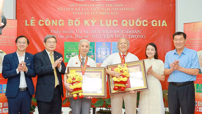 Thầy thuốc Ưu tú Nguyễn Đức Đoàn (thứ ba từ trái sang) và bác sĩ Nguyễn Hữu Trọng (thứ tư từ trái sang) nhận chứng nhận từ đại diện Tổ chức kỷ lục Việt Nam.