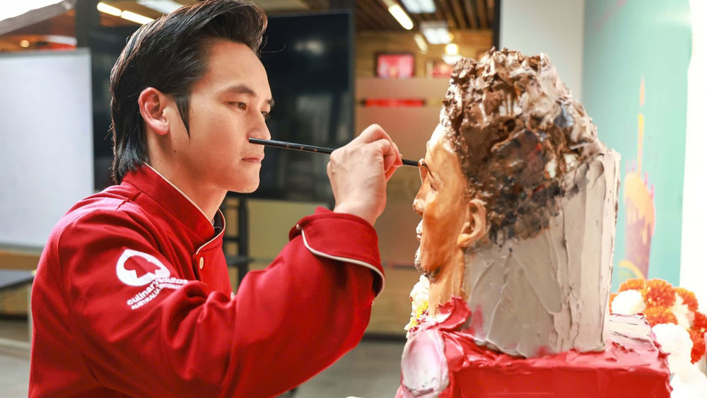 Nghệ nhân Tình Phan đang thực hiện chiếc bánh điêu khắc 3D chứa đựng “mật thư” gửi lời chúc tới cầu thủ Nguyễn Xuân Son. (Ảnh: NVCC)
