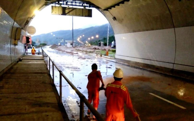 Lực lượng quản lý hầm Hải Vân nỗ lực suốt đêm dọn đất cát, bùn đá sau khi lũ quét. (Ảnh: ĐN)