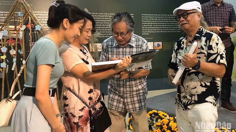 Tác giả, họa sĩ Trịnh Lữ ký sách cho độc giả tại buổi ra mắt sách.