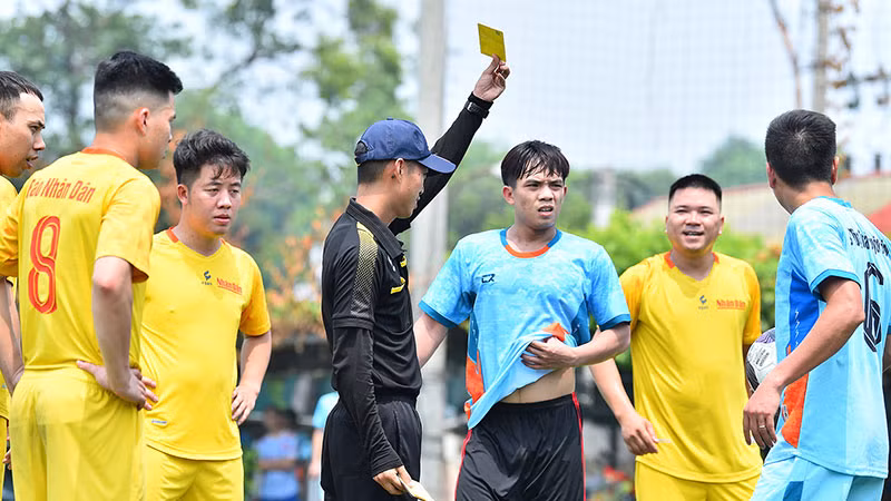 Trọng tài rút thẻ vàng cảnh cáo cầu thủ bên phía Bộ Thông tin và Truyền thông.
