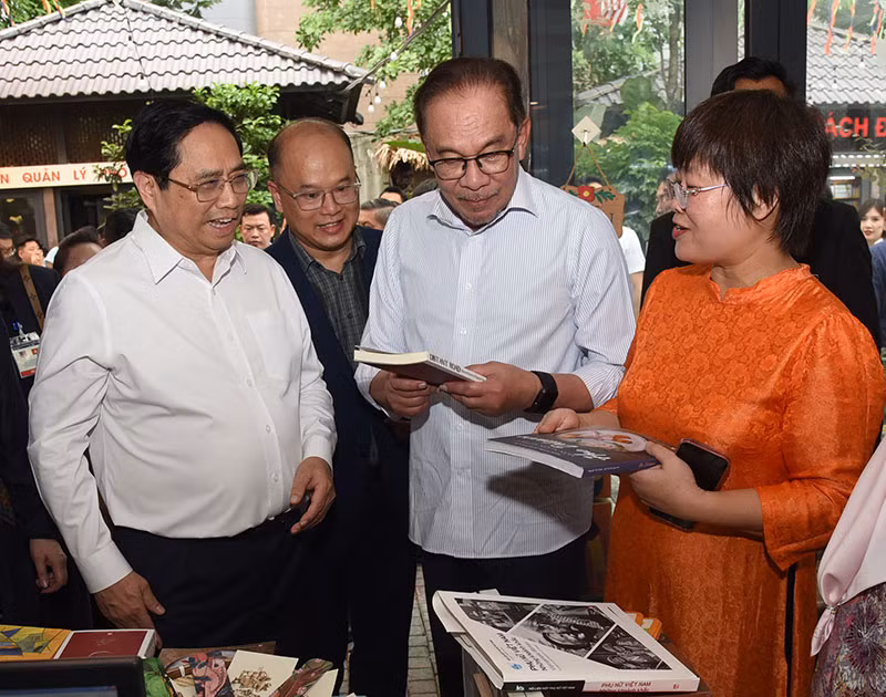 Thủ tướng Phạm Minh Chính và Thủ tướng Malaysia Anwar Ibrahim cùng xem sách.