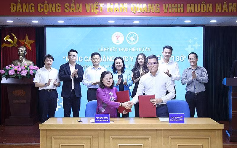 Chủ tịch Hội Thầy thuốc trẻ Việt Nam Hà Anh Đức và Chủ tịch Tổng hội Y học Việt Nam Nguyễn Thị Xuyên bàn giao biên bản ký kết chương trình phối hợp.