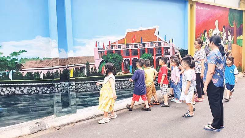 Thiếu nhi xem bức tranh Bến Nhà Rồng được vẽ trong một tuyến hẻm ở quận Phú Nhuận.