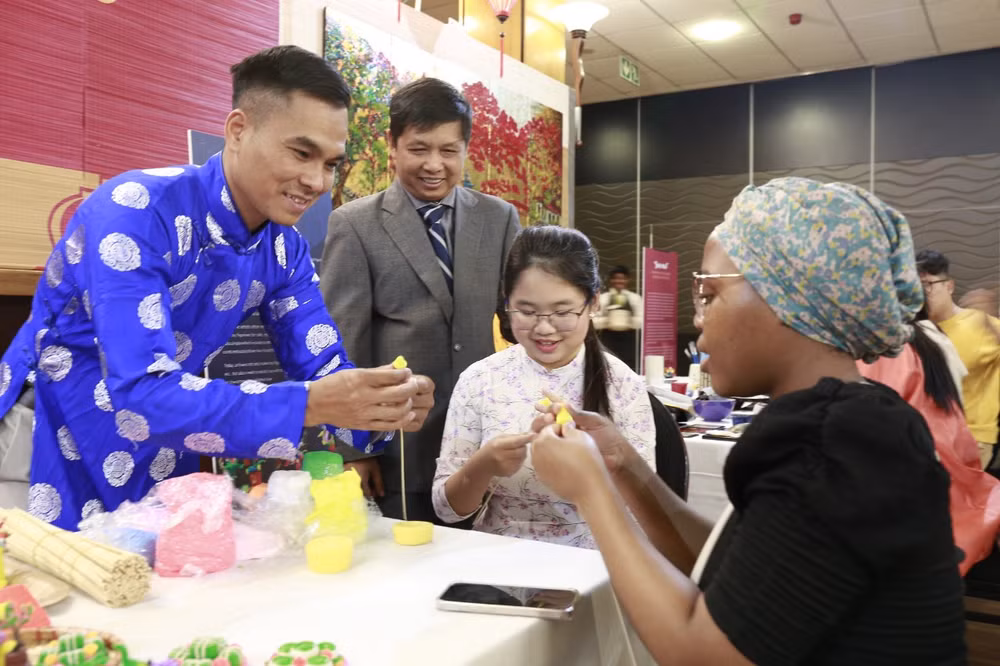 Nghệ nhân Đặng Đình Thường giới thiệu sản phẩm tò he Việt Nam và hướng dẫn khách trải nghiệm.