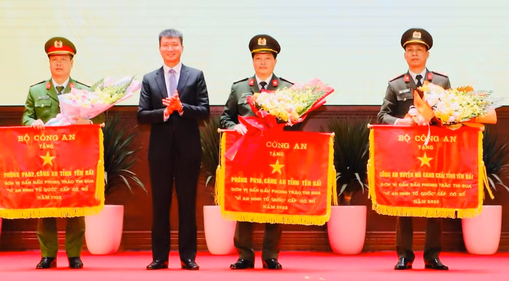 Chủ tịch Ủy ban nhân dân tỉnh Yên Bái trao cờ thi đua cho các đơn vị. (Ảnh: THANH SƠN)